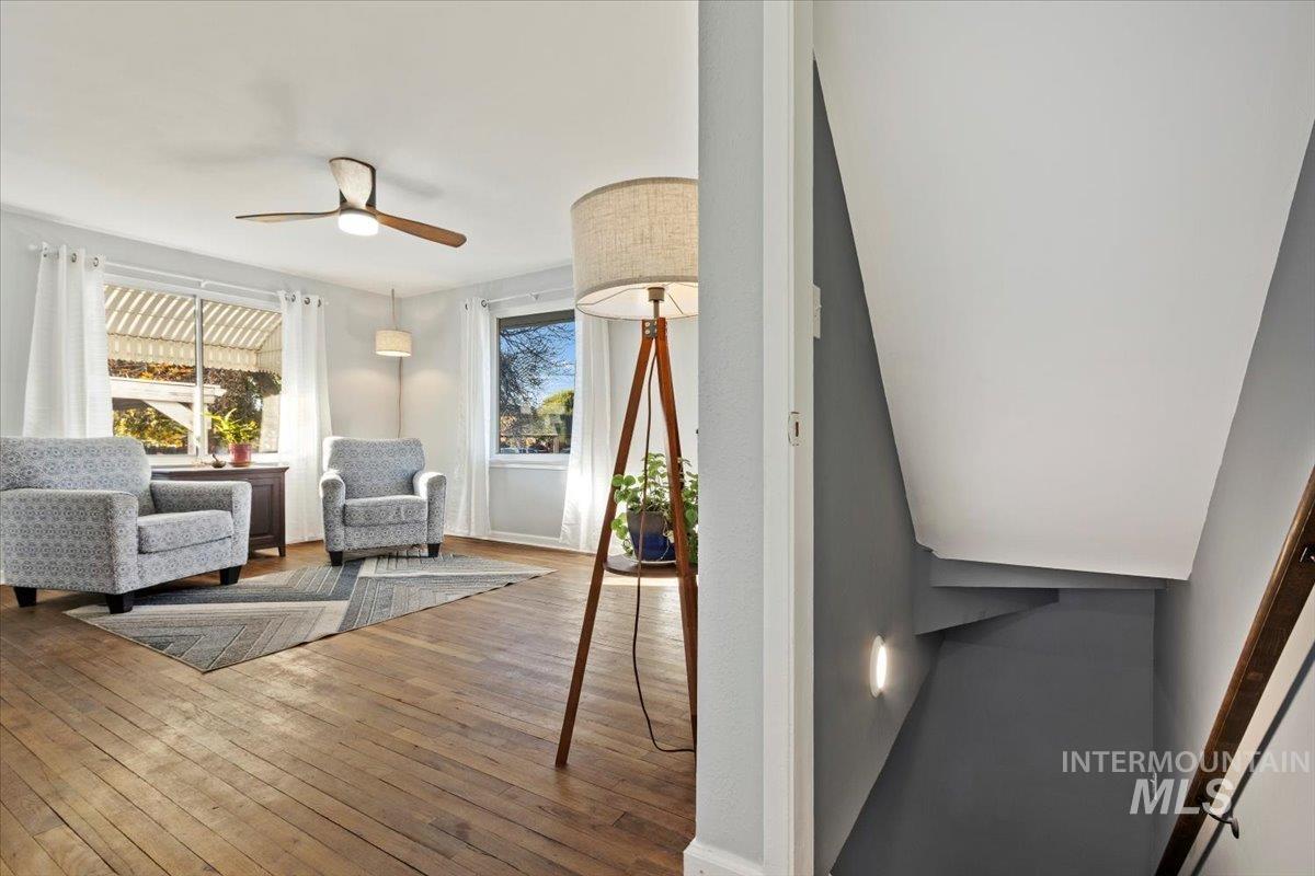 Living area with hardwood / wood-style floors and a ceiling fan