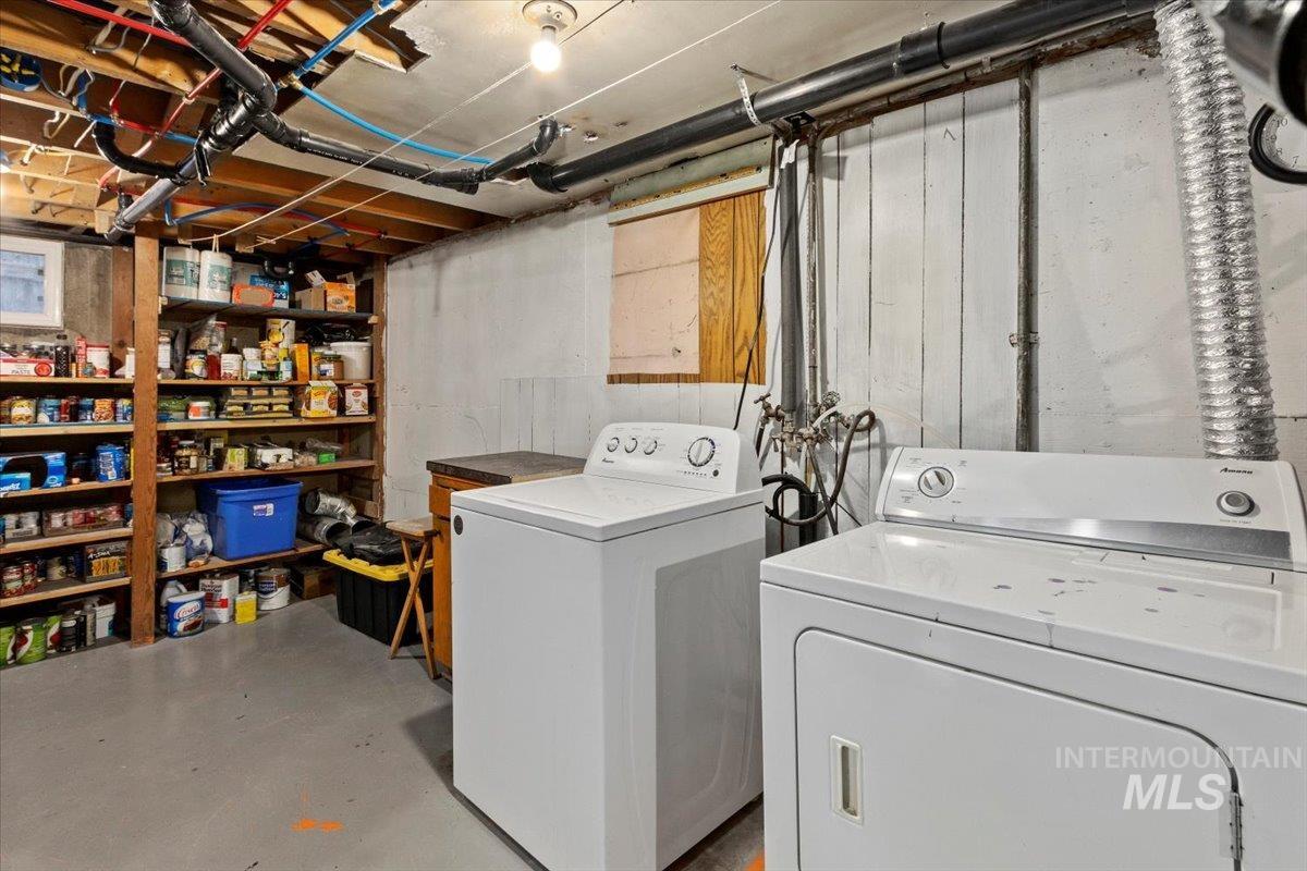 Washroom featuring concrete floors and washing machine and clothes dryer
