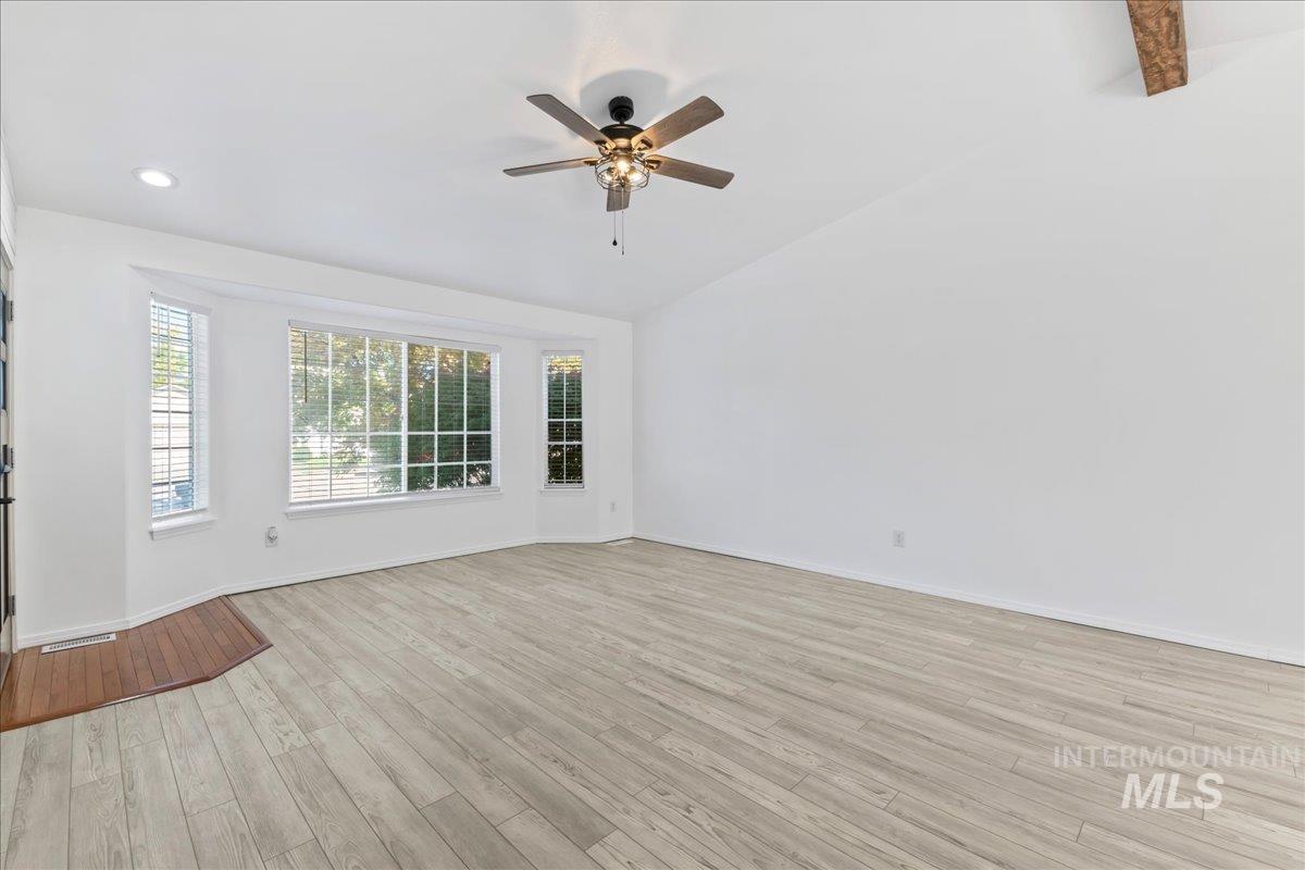 Empty room featuring light wood-style flooring, a ceiling fan, recessed lighting, and high vaulted ceiling
