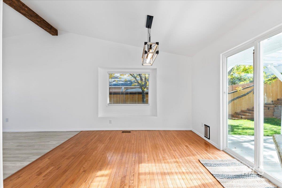 Unfurnished dining area featuring light wood-type flooring and baseboards