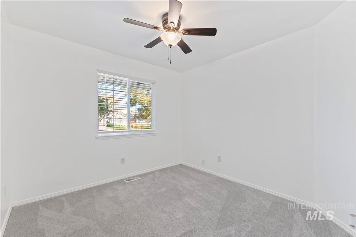 Unfurnished room featuring carpet and ceiling fan
