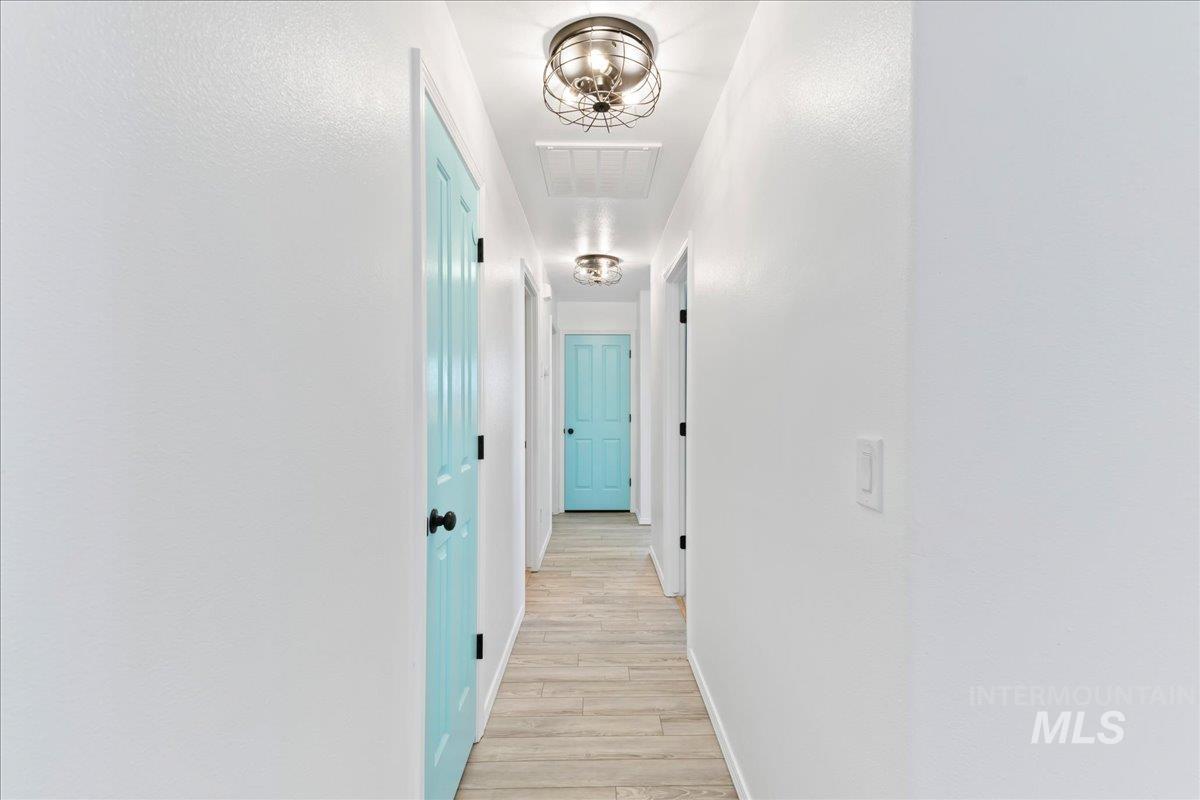 Hall featuring light wood-style flooring and baseboards