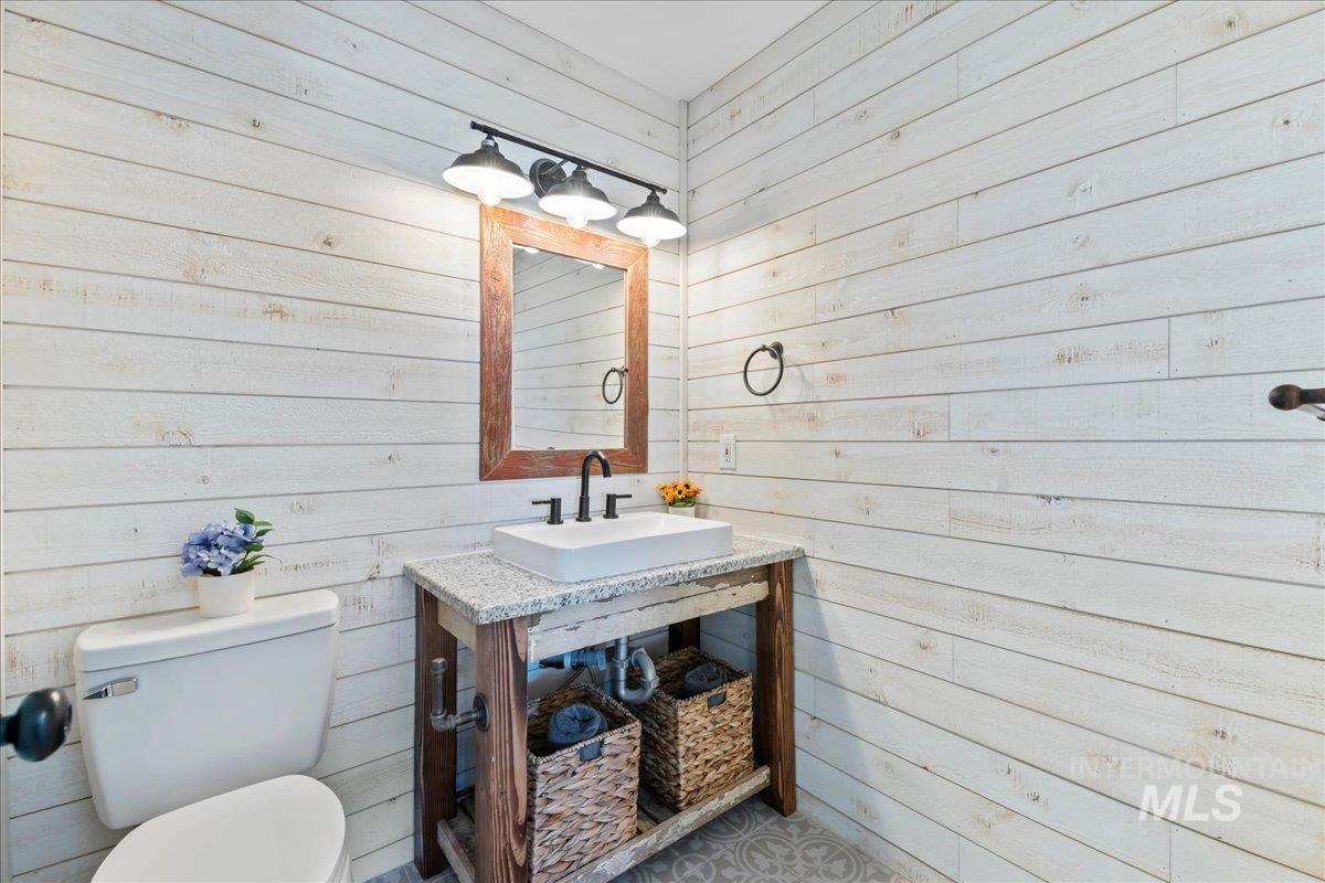 Half bathroom with wood walls and vanity