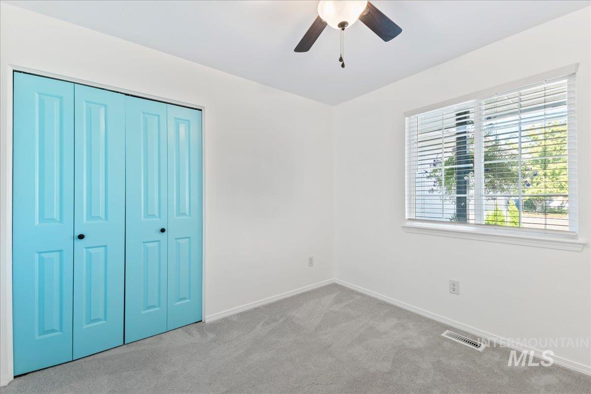 Unfurnished bedroom featuring carpet, a closet, and ceiling fan