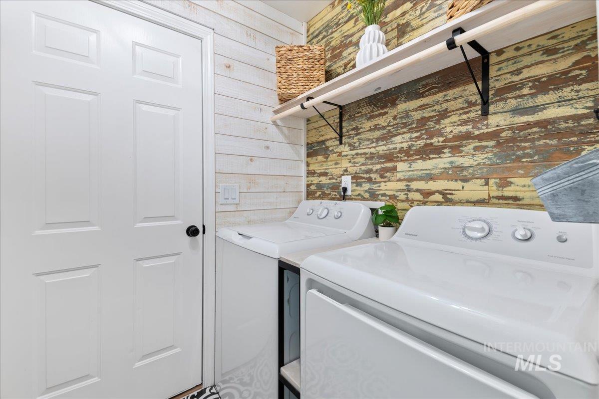 Laundry room with wooden walls and washing machine and dryer