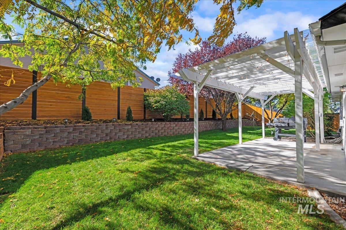 Fenced backyard with a pergola and a patio