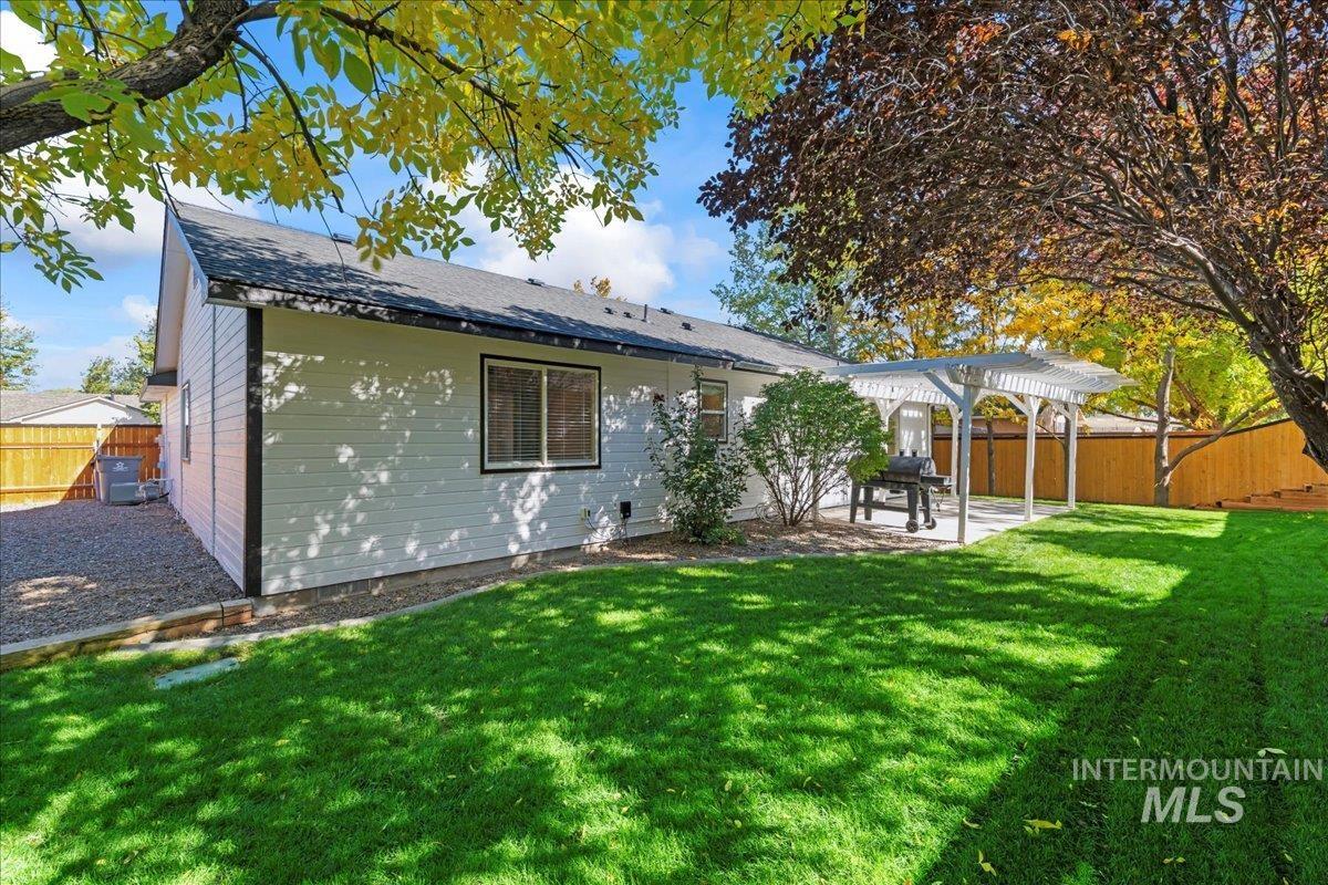 Rear view of house featuring a fenced backyard, a patio, a pergola, and roof with shingles