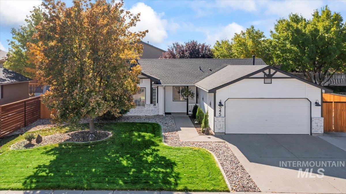 Single story home featuring a shingled roof, driveway, and a garage