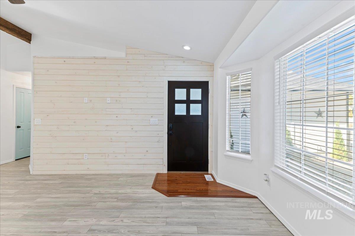 Foyer featuring vaulted ceiling, light wood-style floors, and recessed lighting