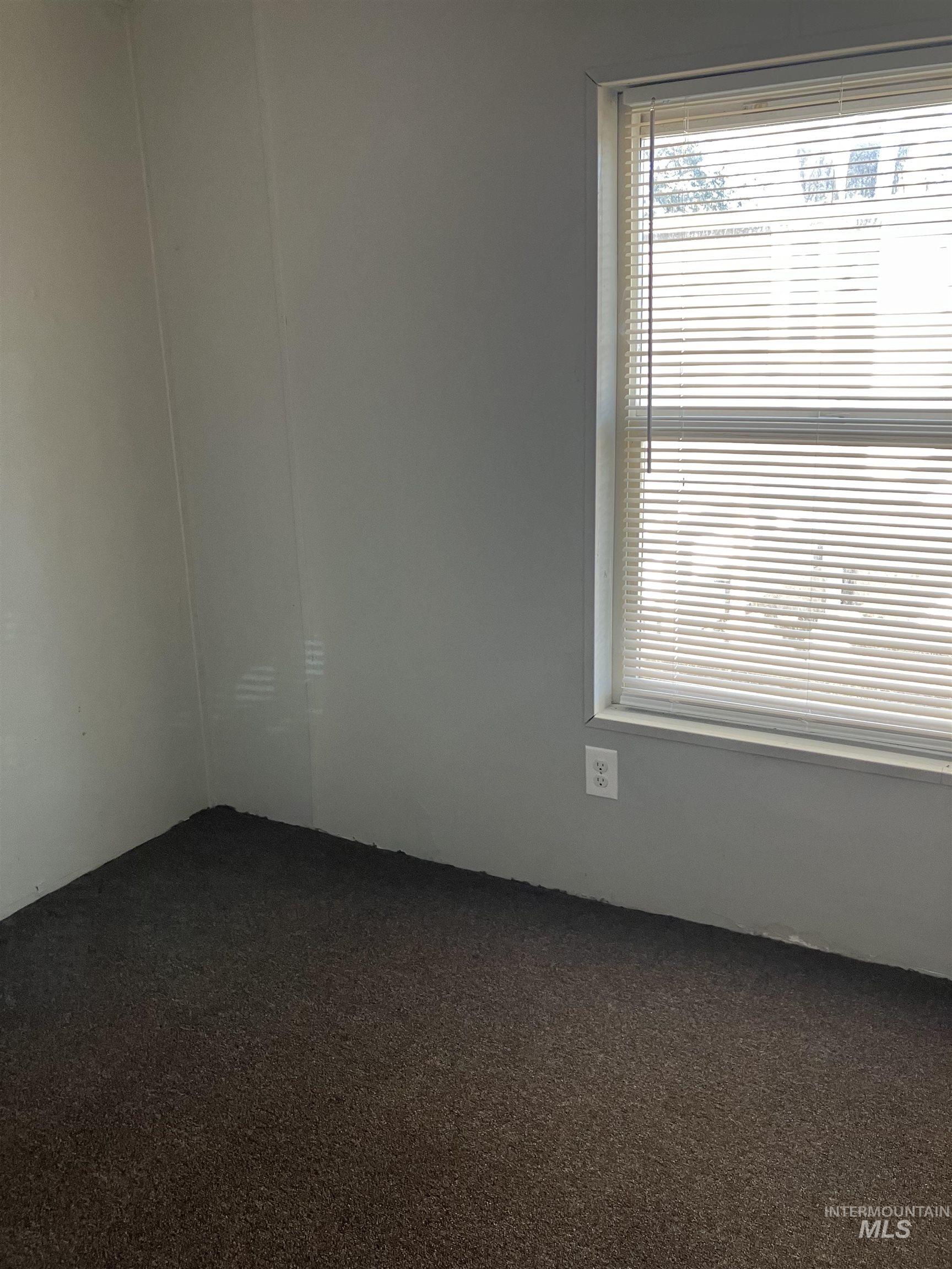 Unfurnished room with dark colored carpet