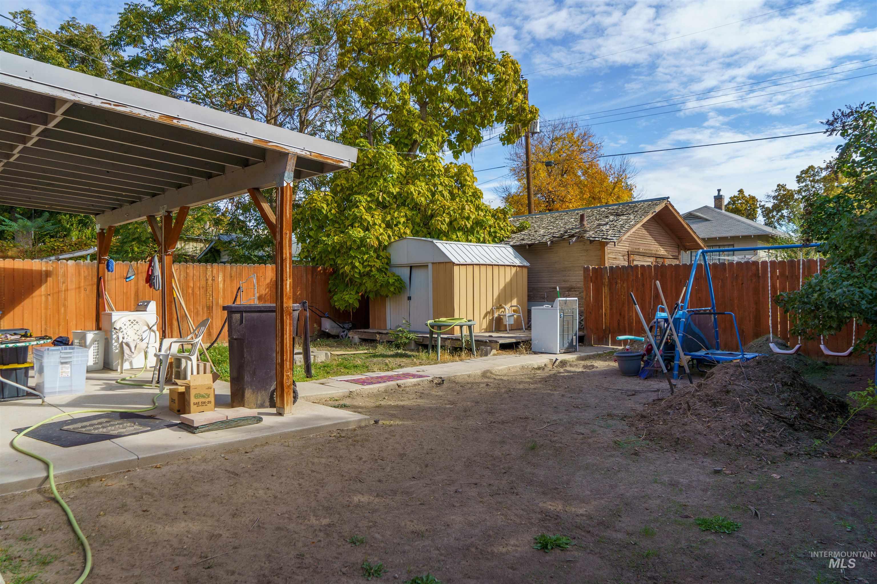 Fenced backyard with a storage shed and a patio area