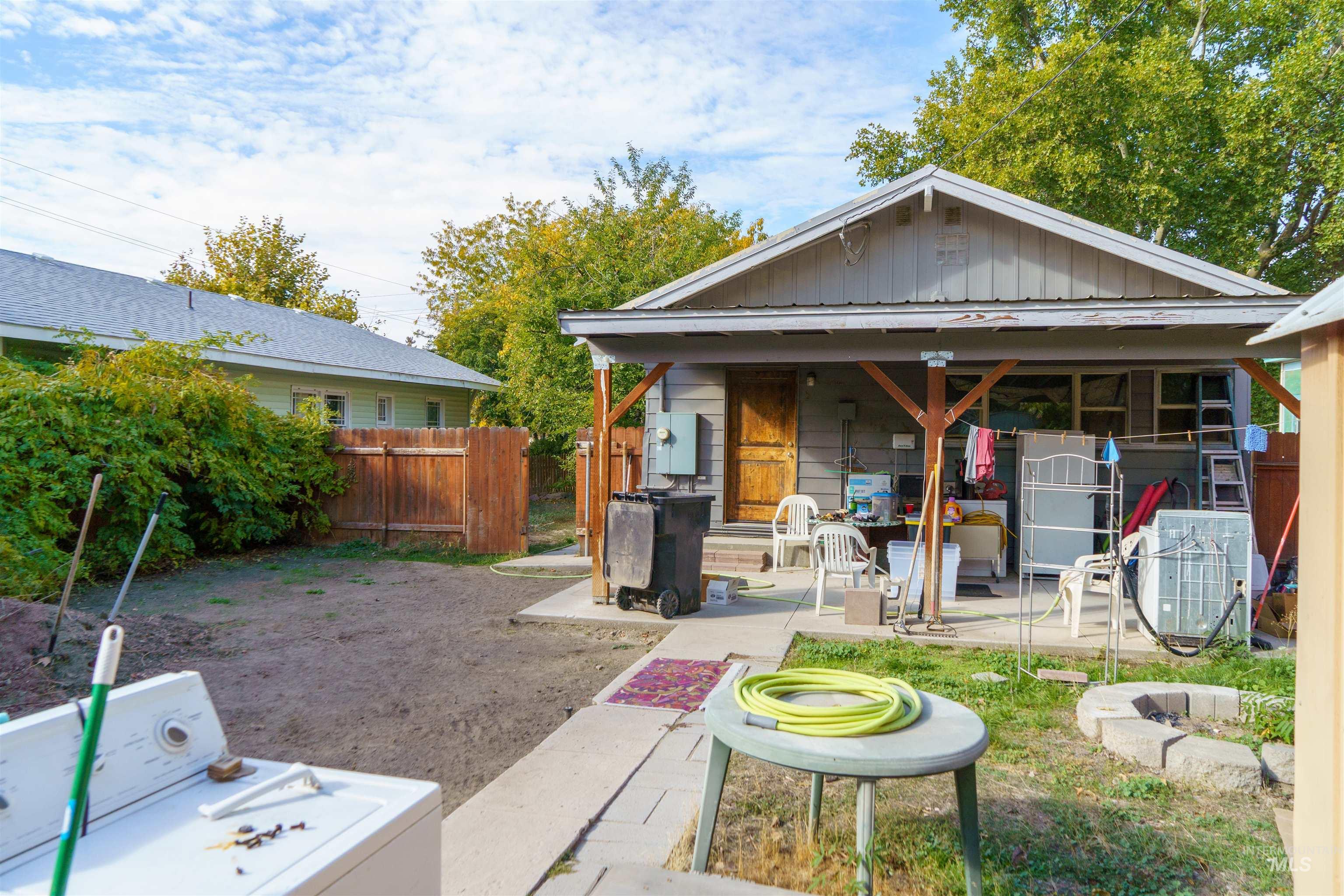 View of front of home featuring board and batten siding, washer / dryer, and a patio
