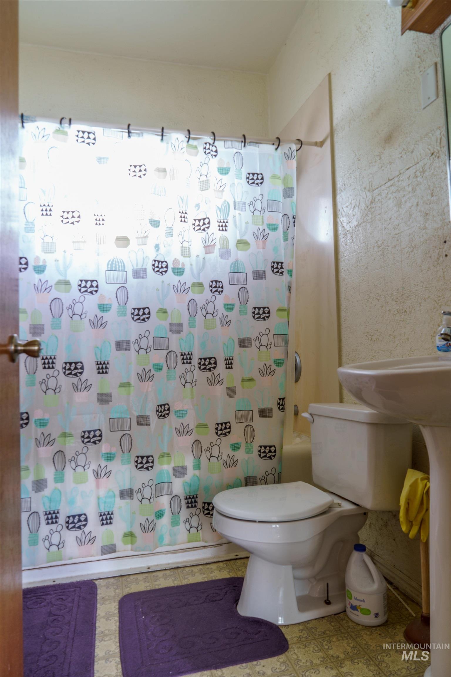 Full bath featuring shower / bath combo and toilet