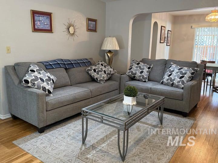 Living area with wood finished floors and arched walkways
