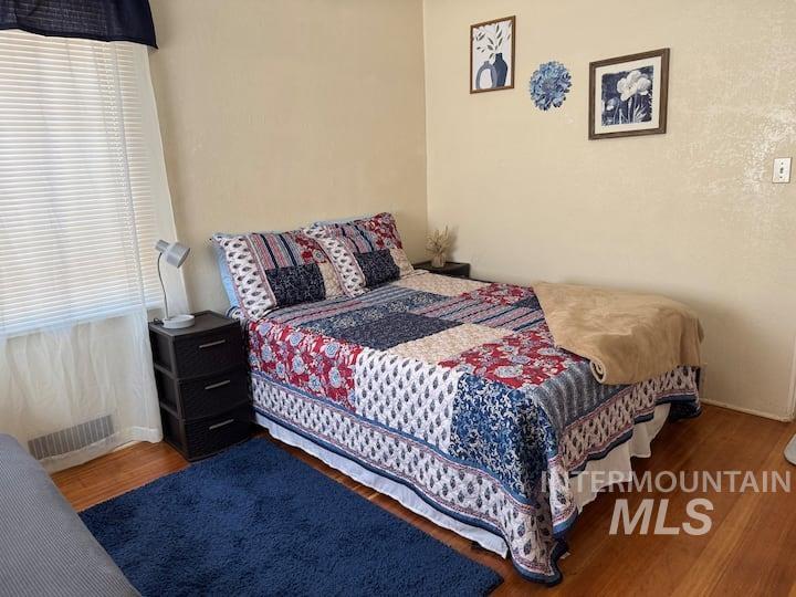 Bedroom with wood finished floors and baseboards