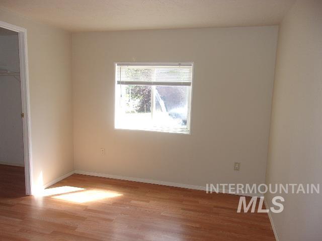 Unfurnished bedroom featuring light wood-type flooring and a spacious closet