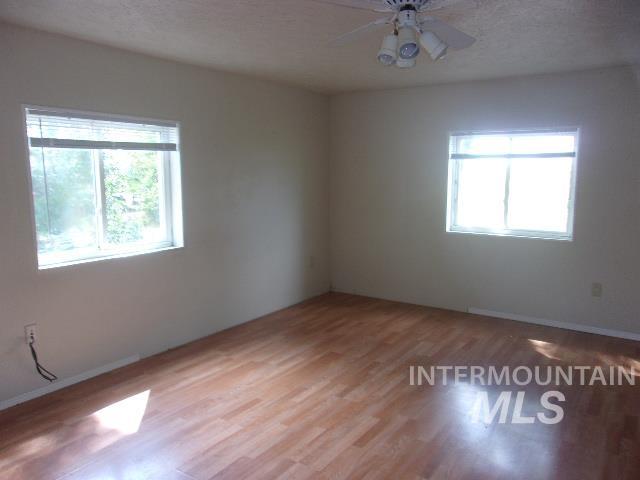 Unfurnished room featuring wood finished floors, a textured ceiling, and ceiling fan