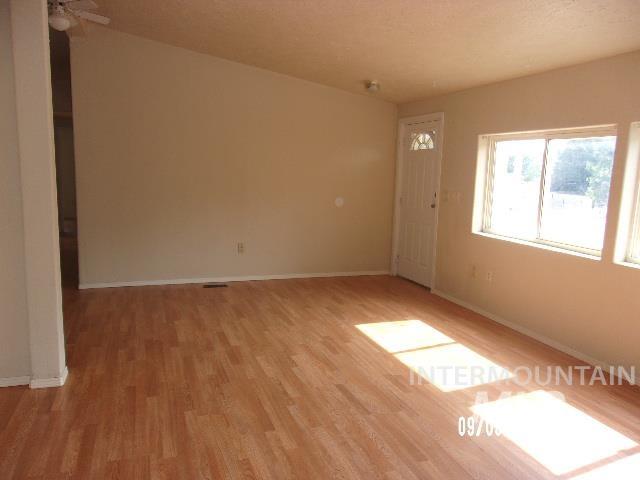 Empty room with light wood-style flooring and a textured ceiling