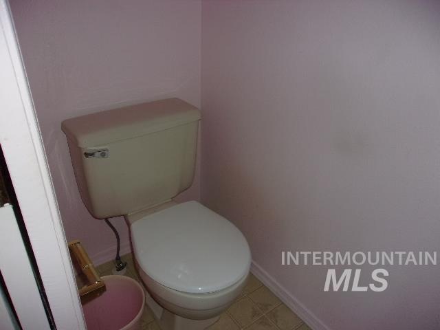 Bathroom featuring toilet and light tile patterned flooring