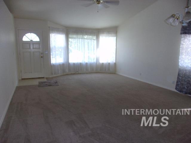 Entrance foyer featuring carpet floors and a ceiling fan