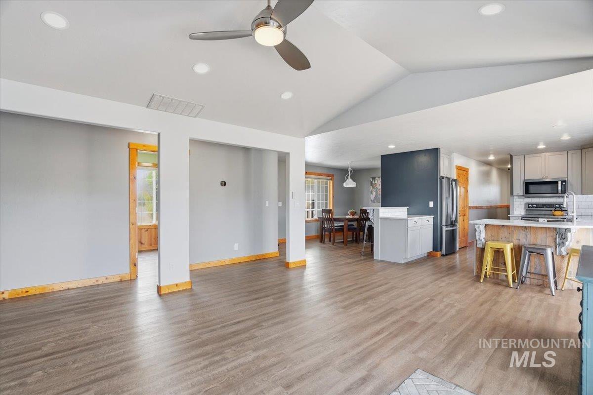 Living area featuring dark wood finished floors, recessed lighting, plenty of natural light, a ceiling fan, and vaulted ceiling