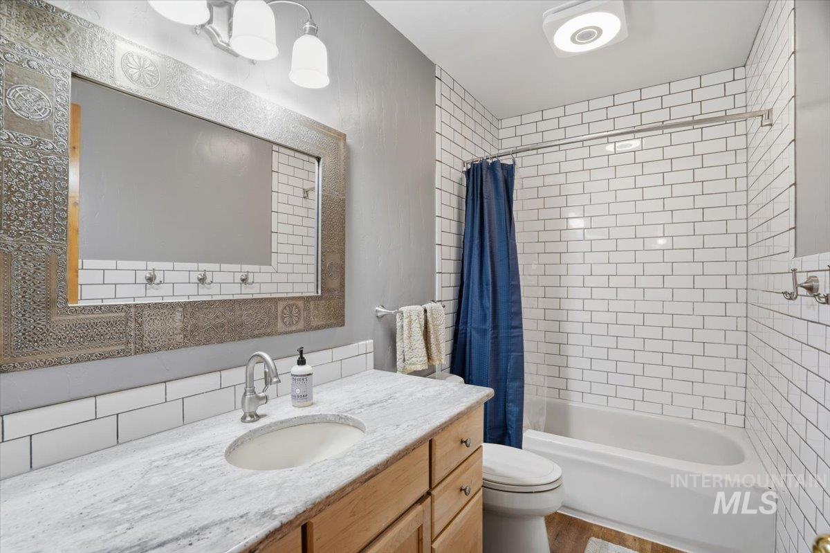 Bathroom featuring shower / bath combo with shower curtain and vanity