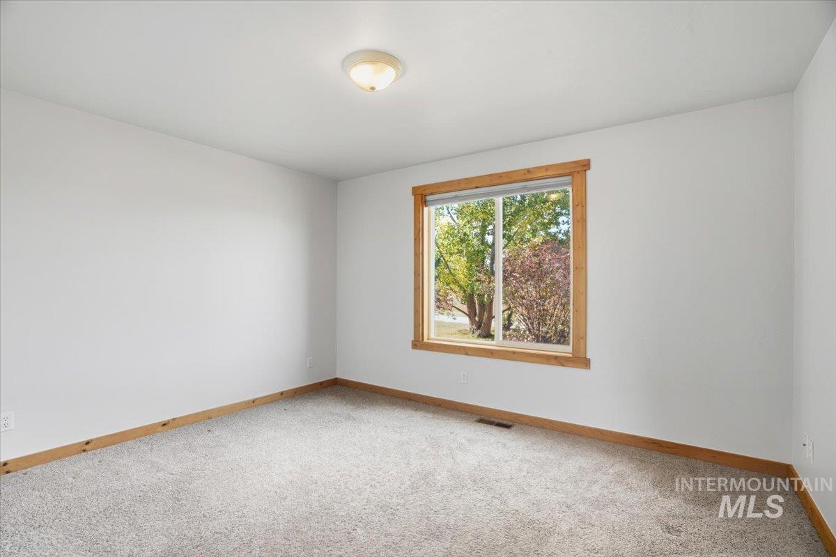 Spare room featuring carpet floors and baseboards