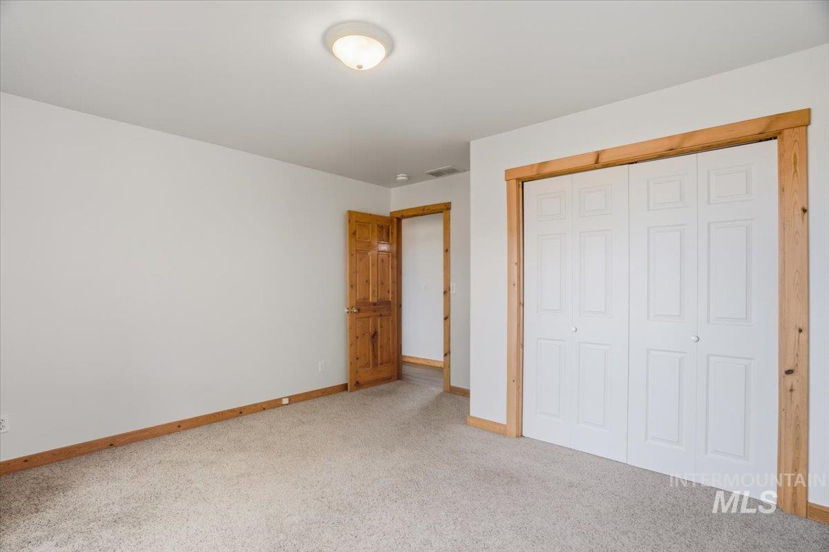 Unfurnished bedroom with light colored carpet and a closet