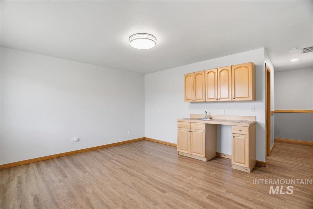 Kitchen with light countertops, light brown cabinets, and light wood finished floors