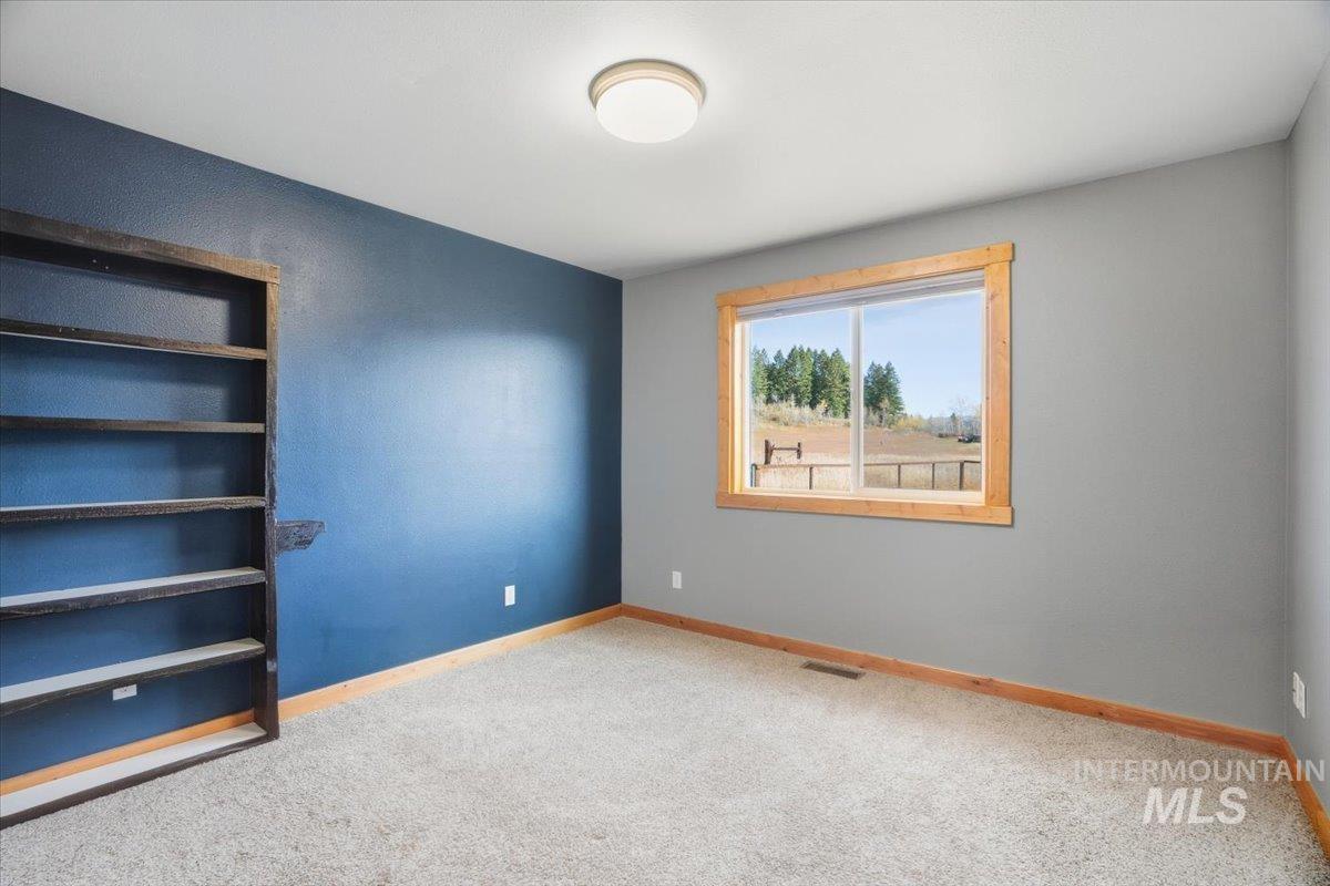 Spare room featuring carpet and baseboards