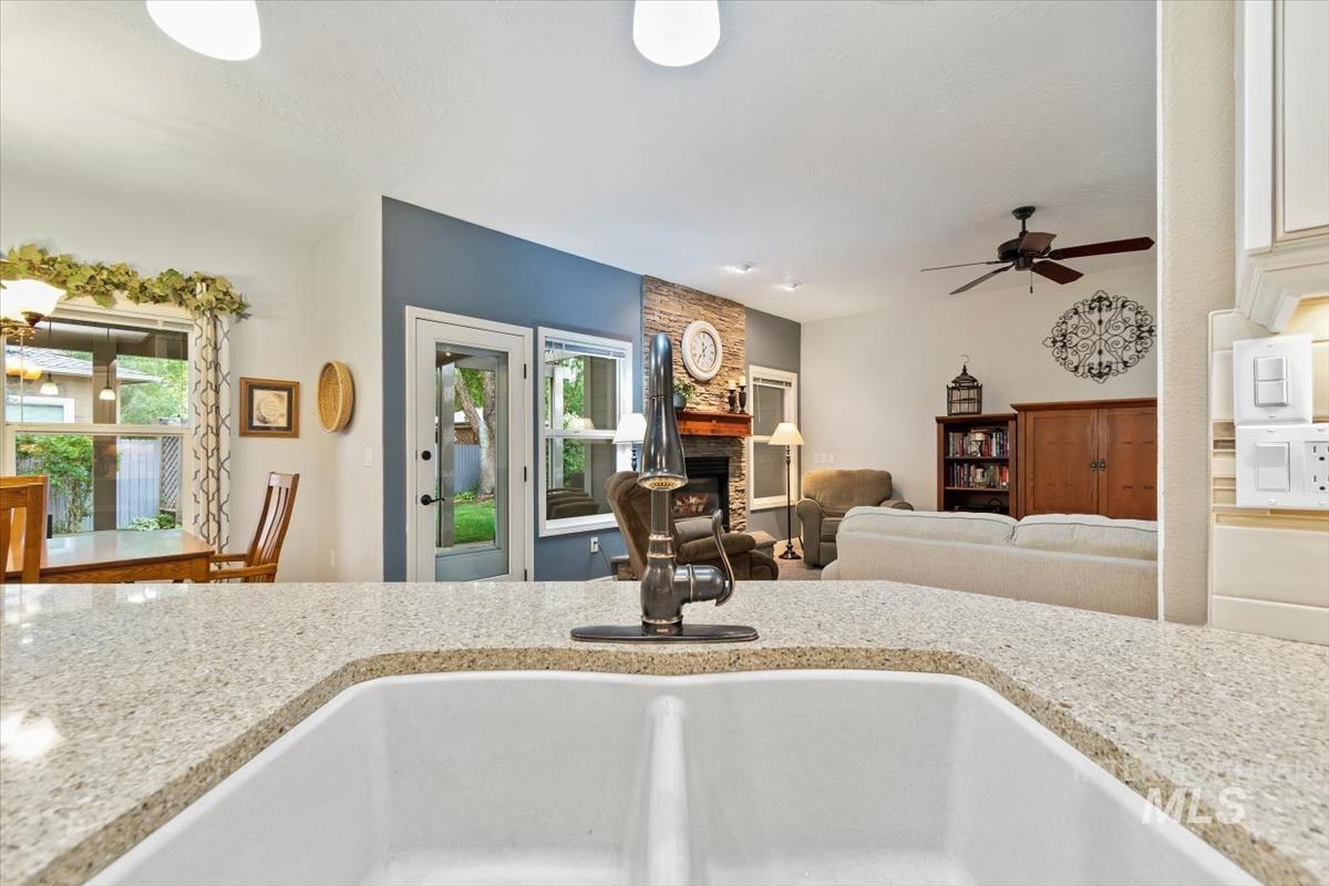 Kitchen with a stone fireplace, plenty of natural light, open floor plan, and light stone countertops