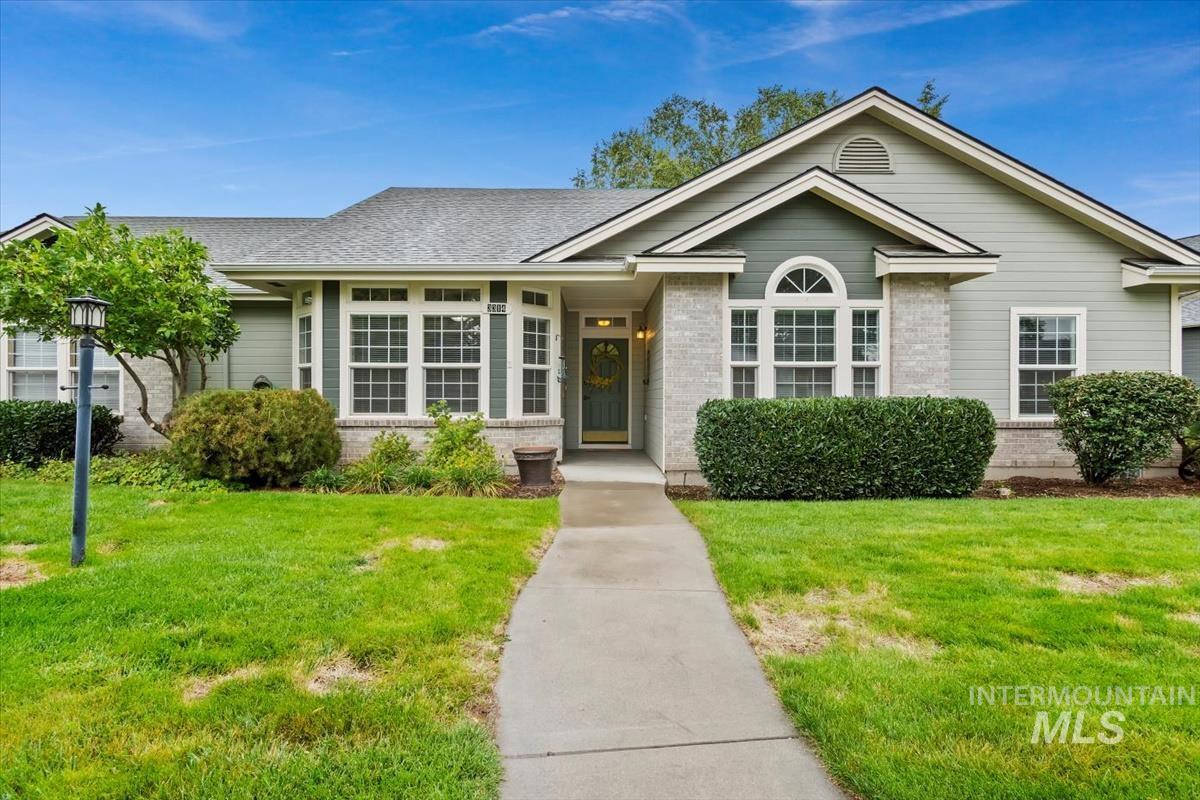 Ranch-style home with a front lawn, brick siding, and a shingled roof