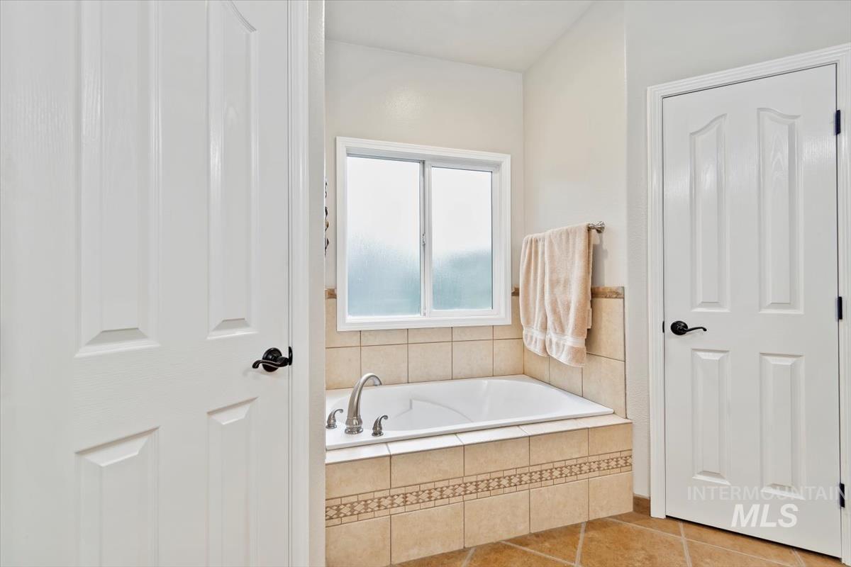 Bathroom with a bath and tile patterned flooring
