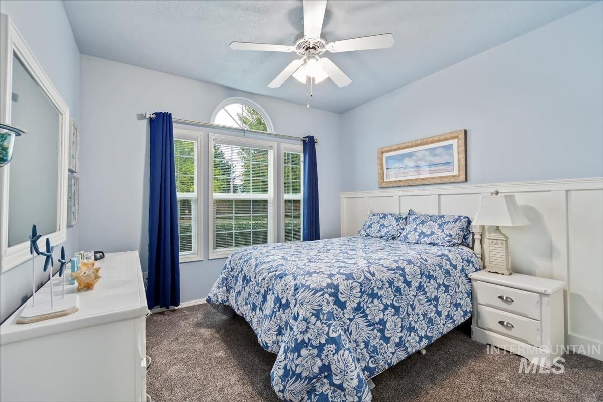 Bedroom featuring dark colored carpet and ceiling fan