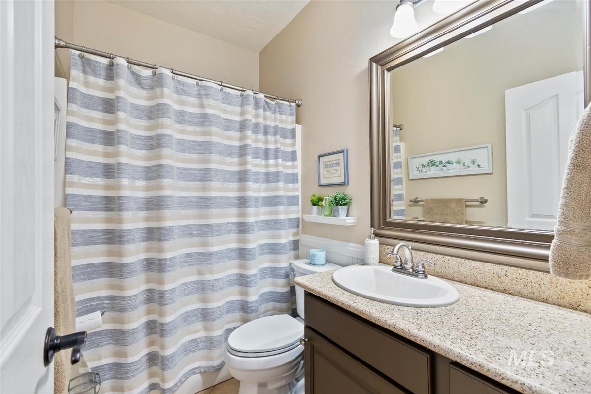 Full bath with a shower with shower curtain and vanity