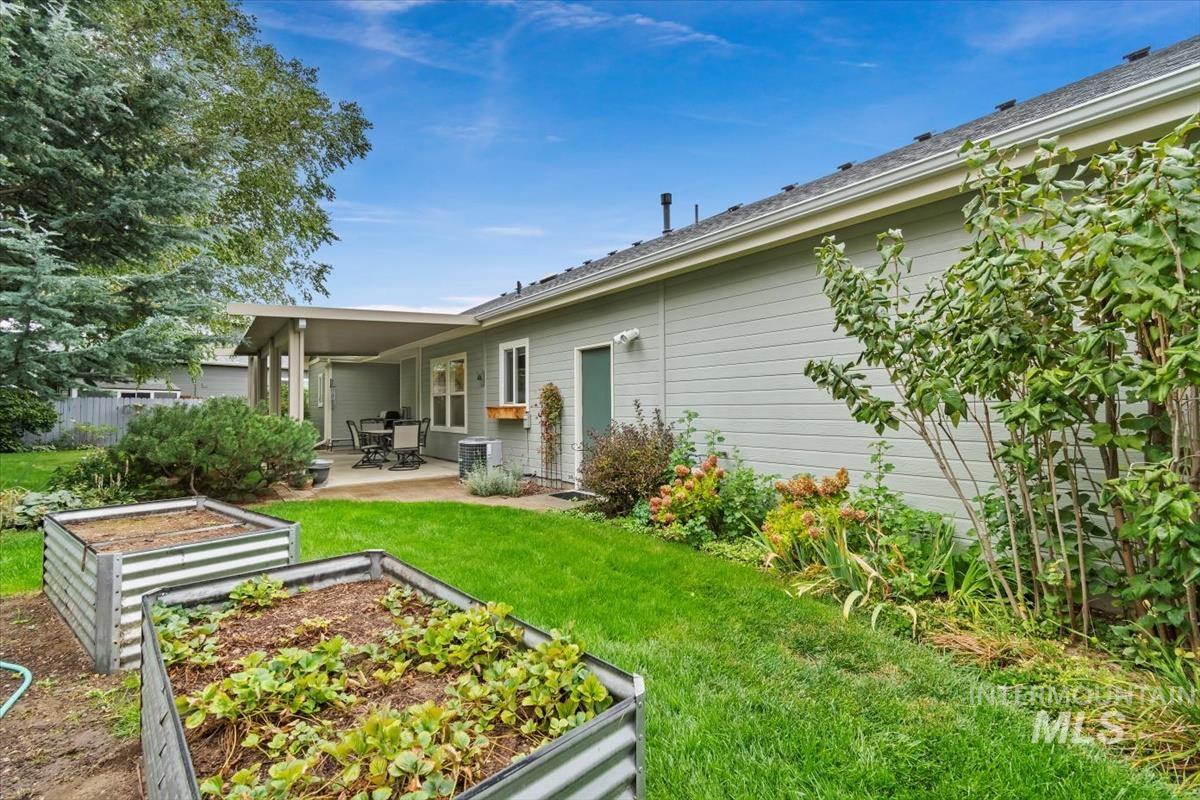 Back of house featuring a garden, a patio area, and a yard