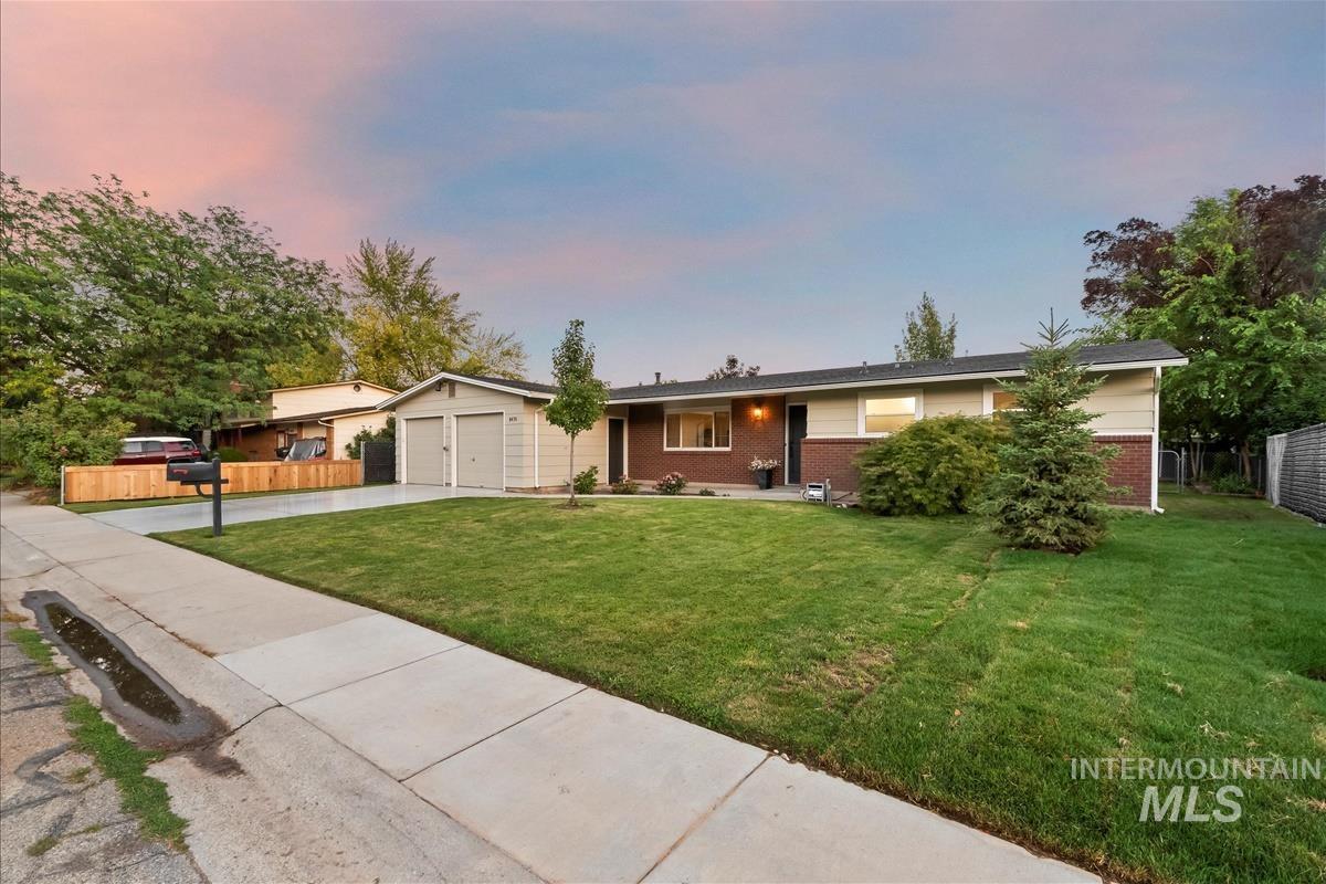 Single story home with driveway, brick siding, and a porch