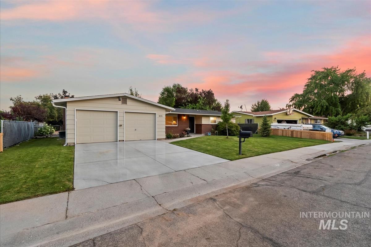 Ranch-style home featuring concrete driveway and a garage