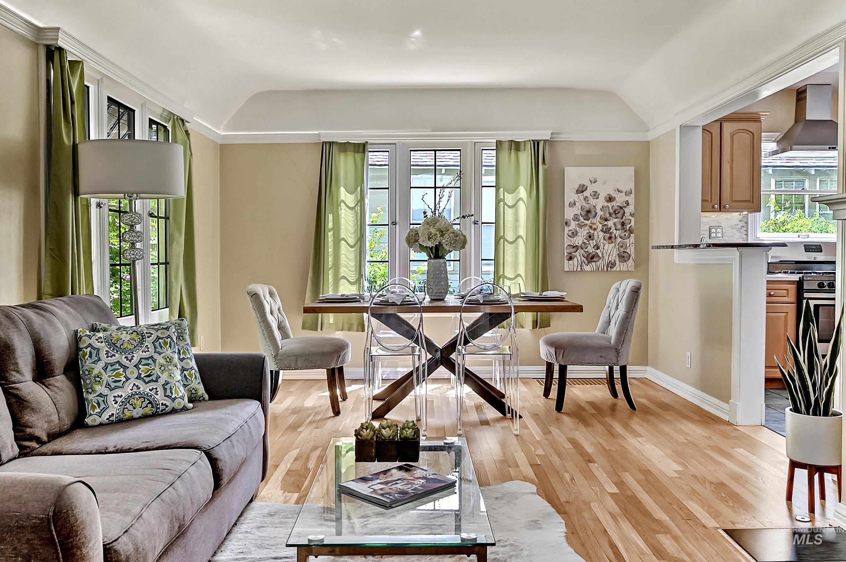 Light-filled space with hardwood floors, coved ceiling & classic windows that frame garden views. Opens seamlessly to the kitchen for an airy, connected feel.
