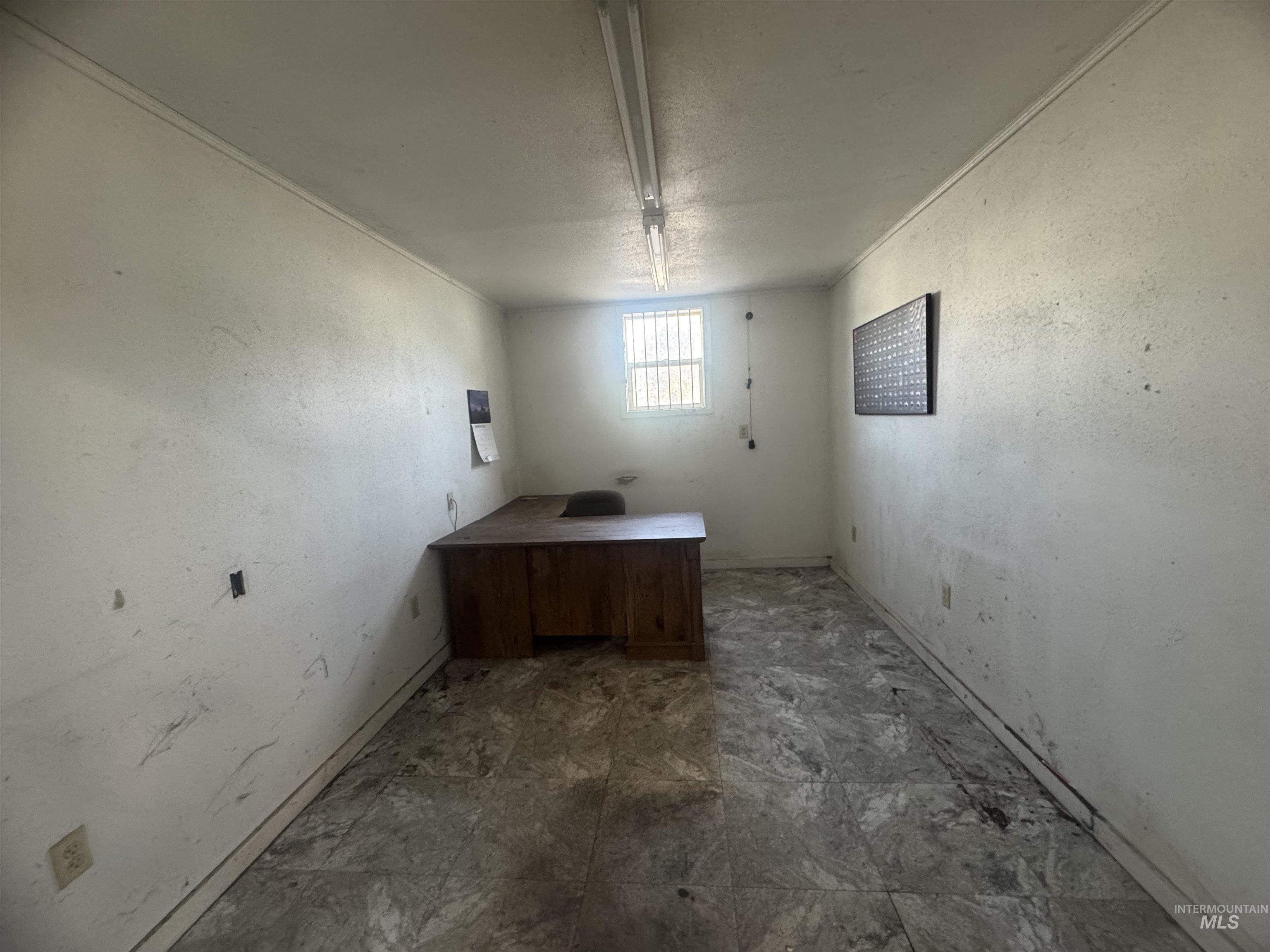 Unfurnished office with a textured ceiling and a textured wall