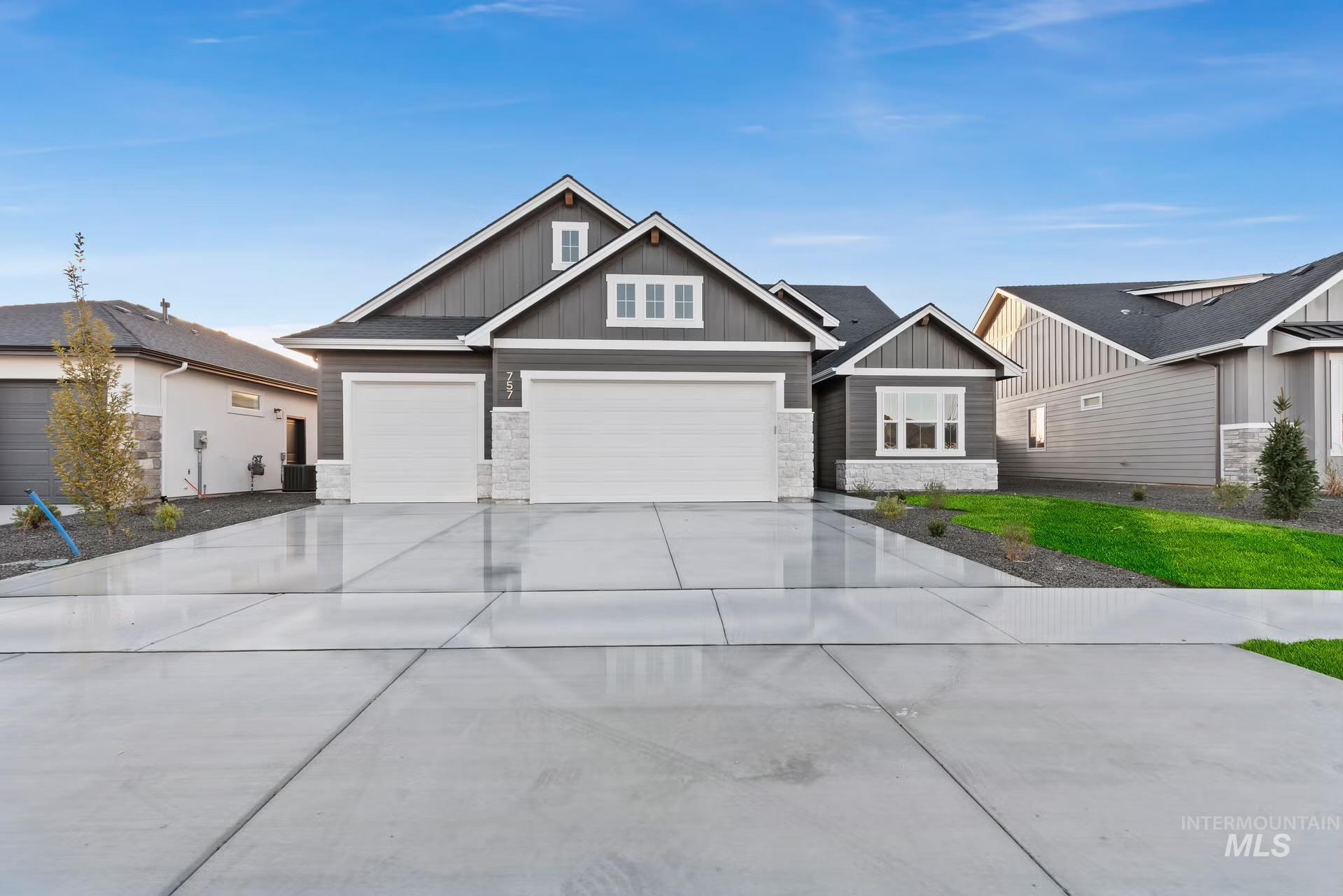 Craftsman-style home featuring board and batten siding, stone siding, concrete driveway, and a garage