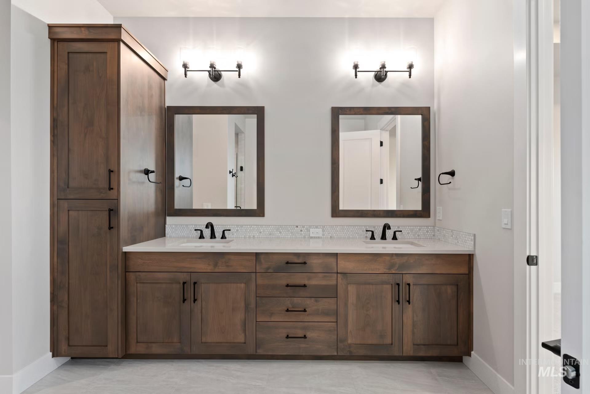 Bathroom with double vanity and baseboards