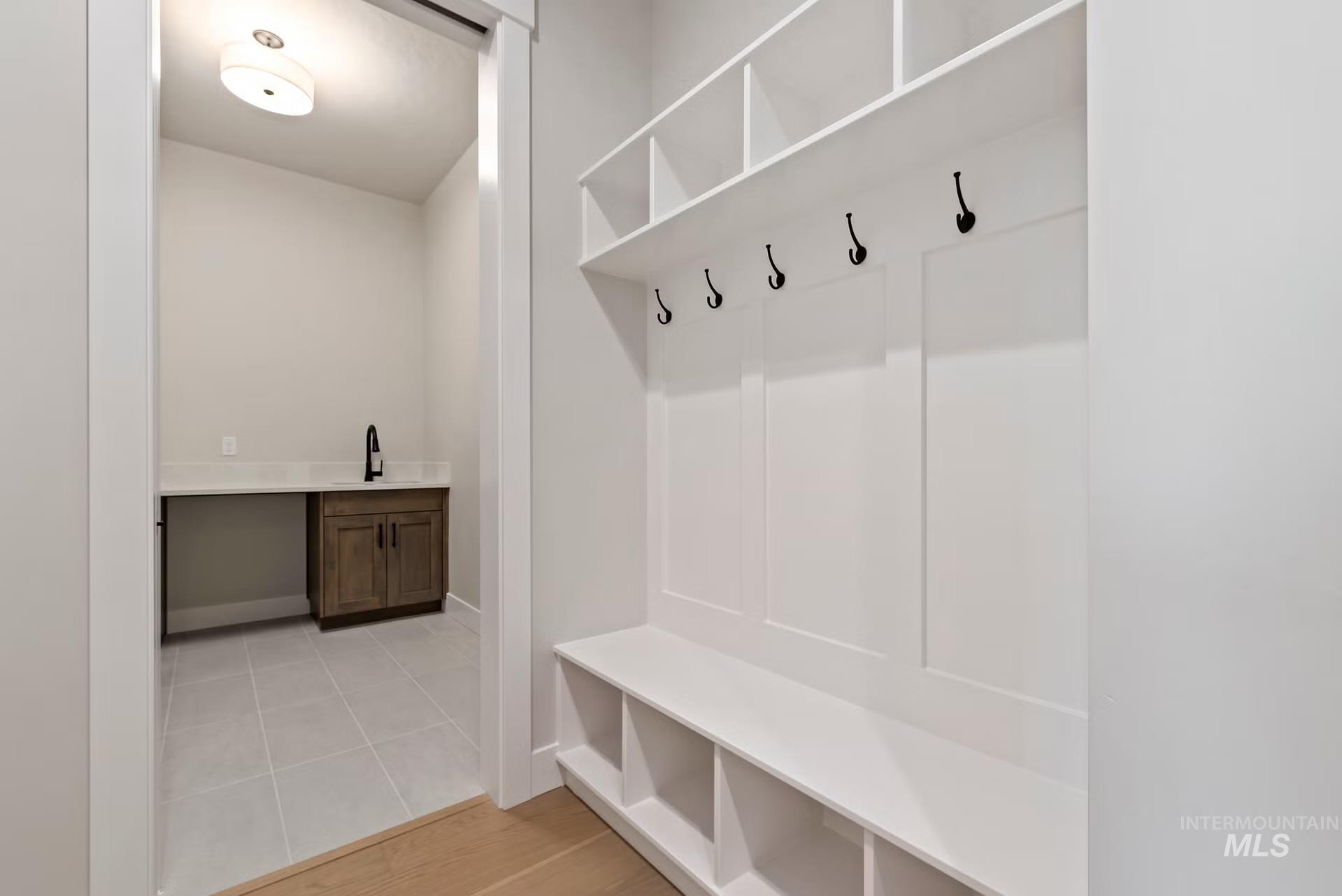Mudroom featuring light tile patterned flooring and a sink