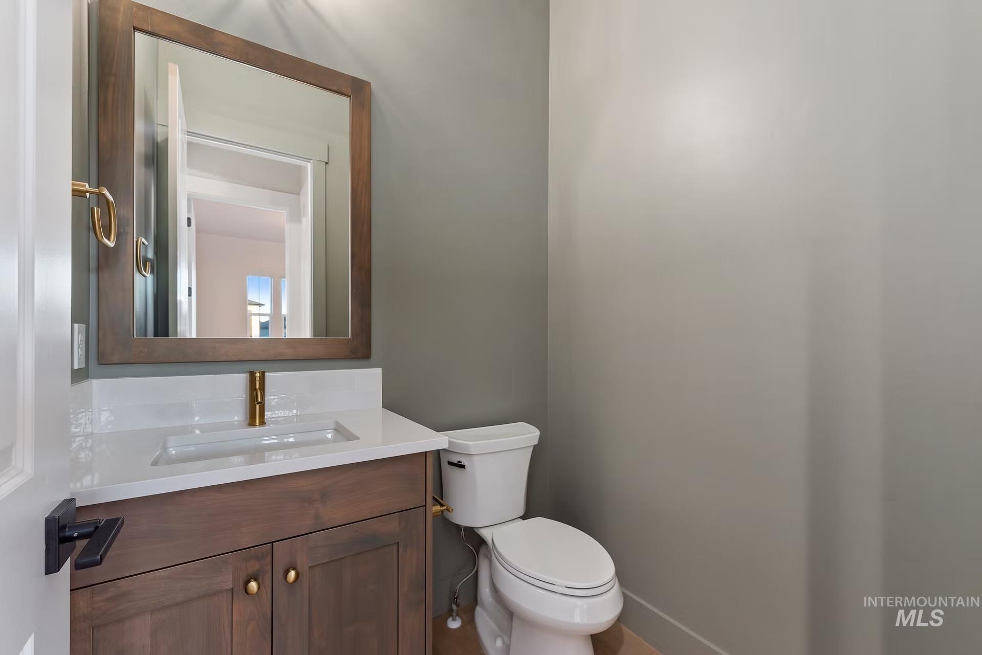 Half bathroom with vanity and toilet