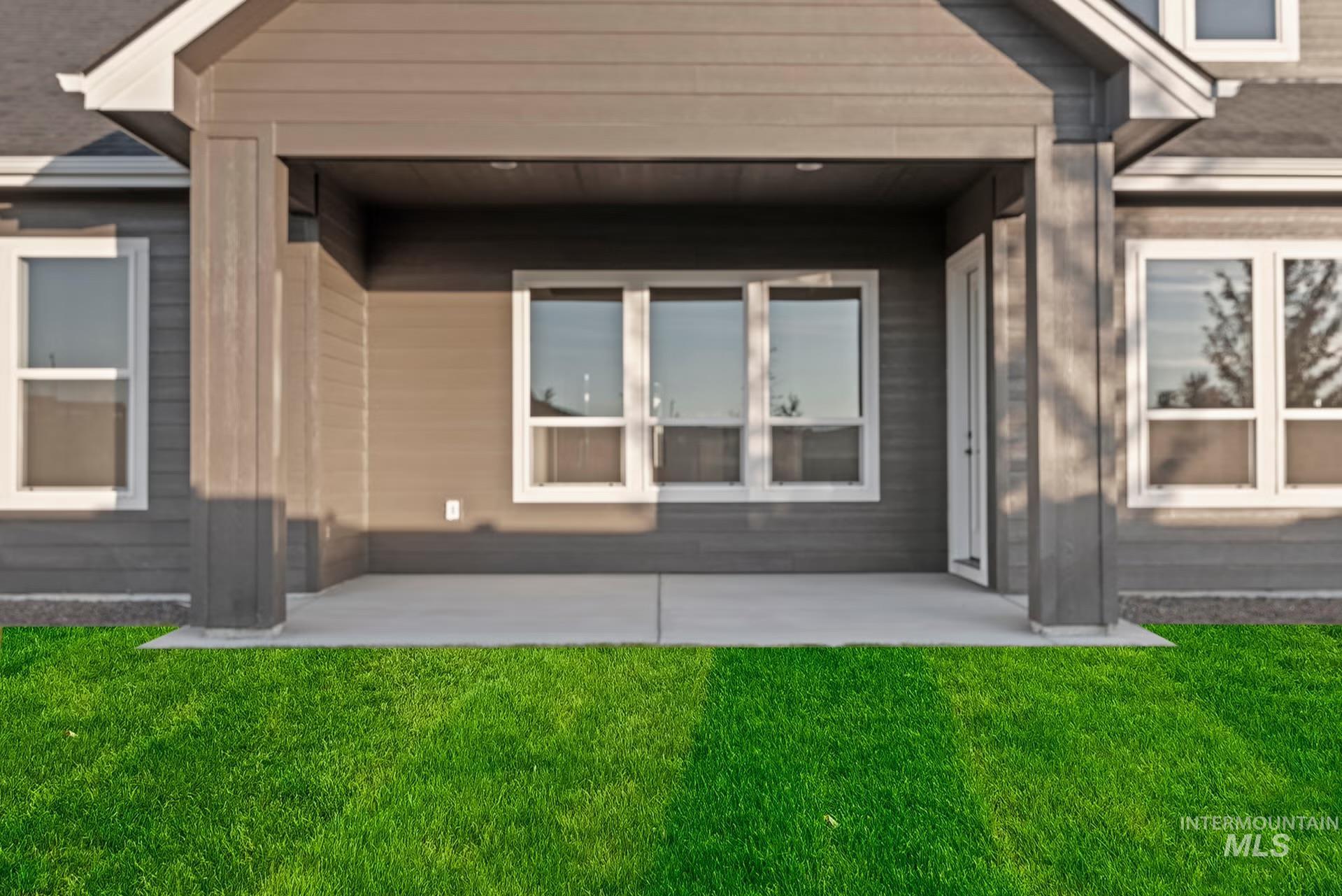 Rear view of property featuring a patio area and a lawn