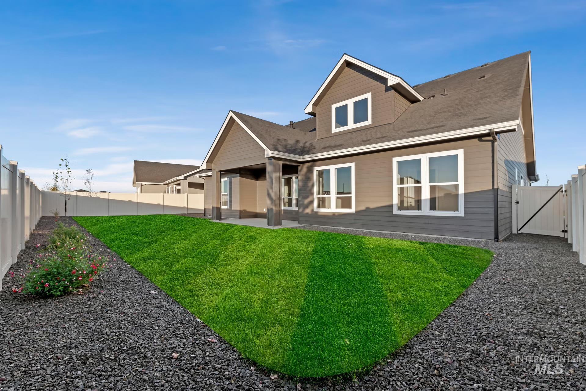 Rear view of property with a patio area, a fenced backyard, a gate, and a shingled roof