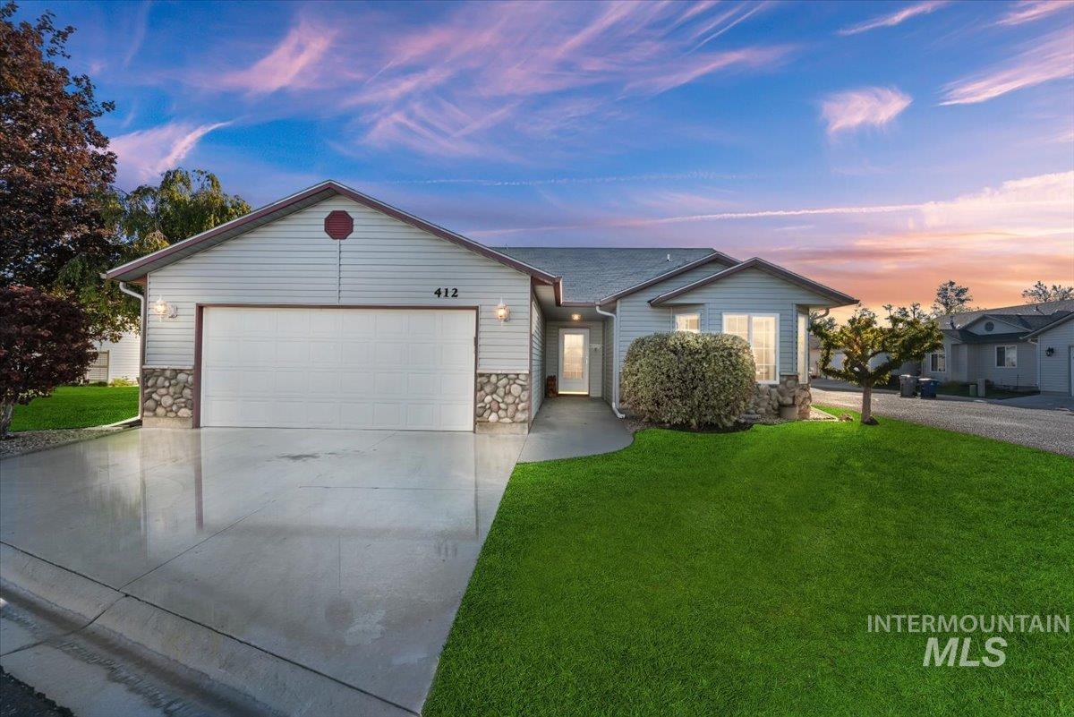 Ranch-style home featuring stone, siding, a large corner lot, driveway, and a 2-car garage