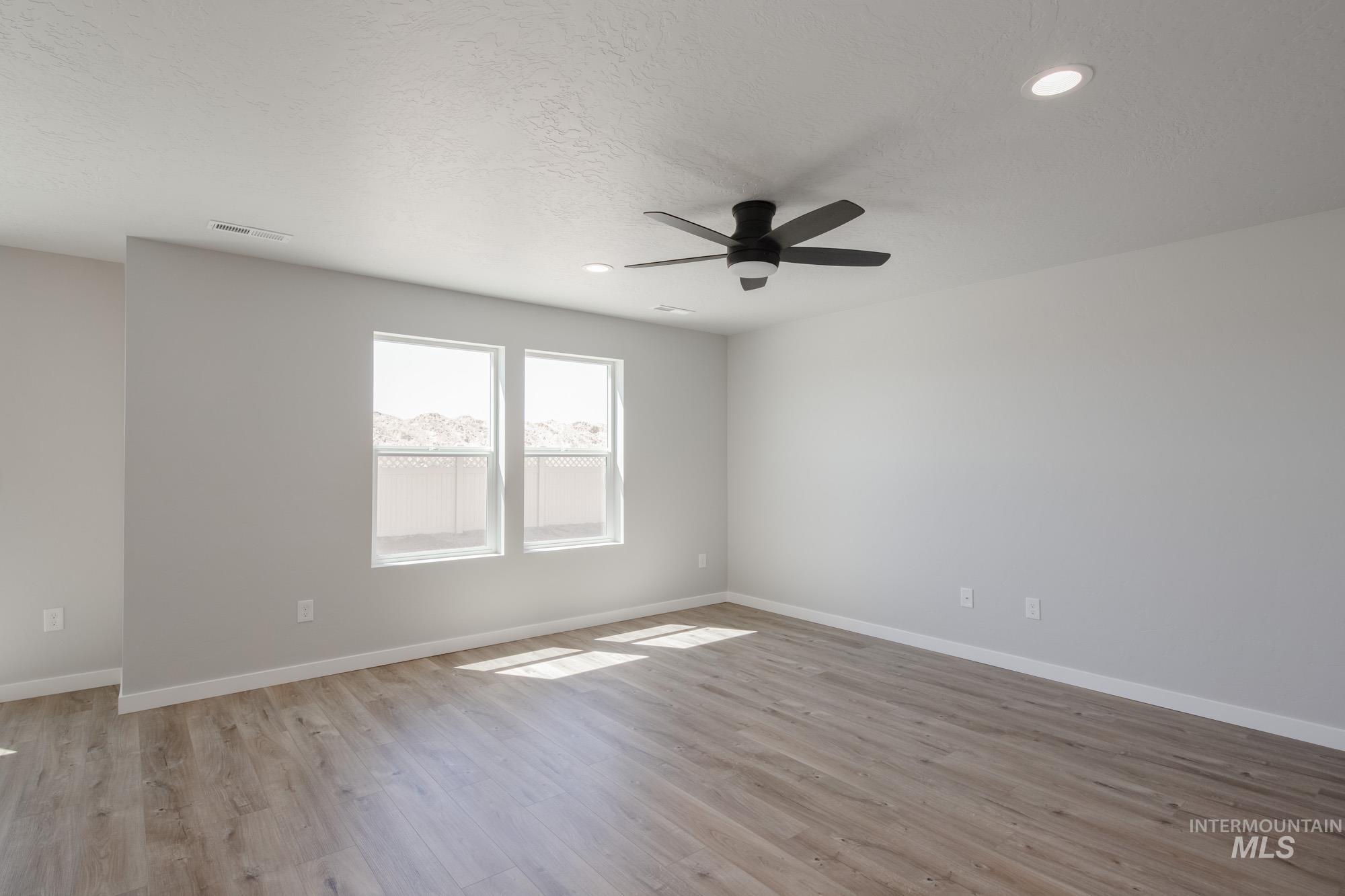 Spare room featuring light wood-style flooring, a textured ceiling, ceiling fan, and recessed lighting