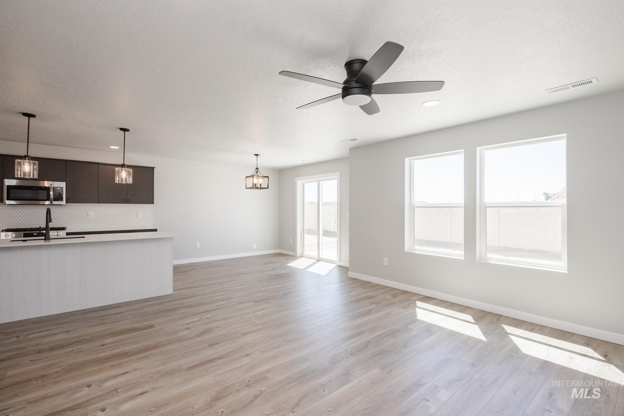 Unfurnished living room with light wood-style floors, a ceiling fan, and recessed lighting