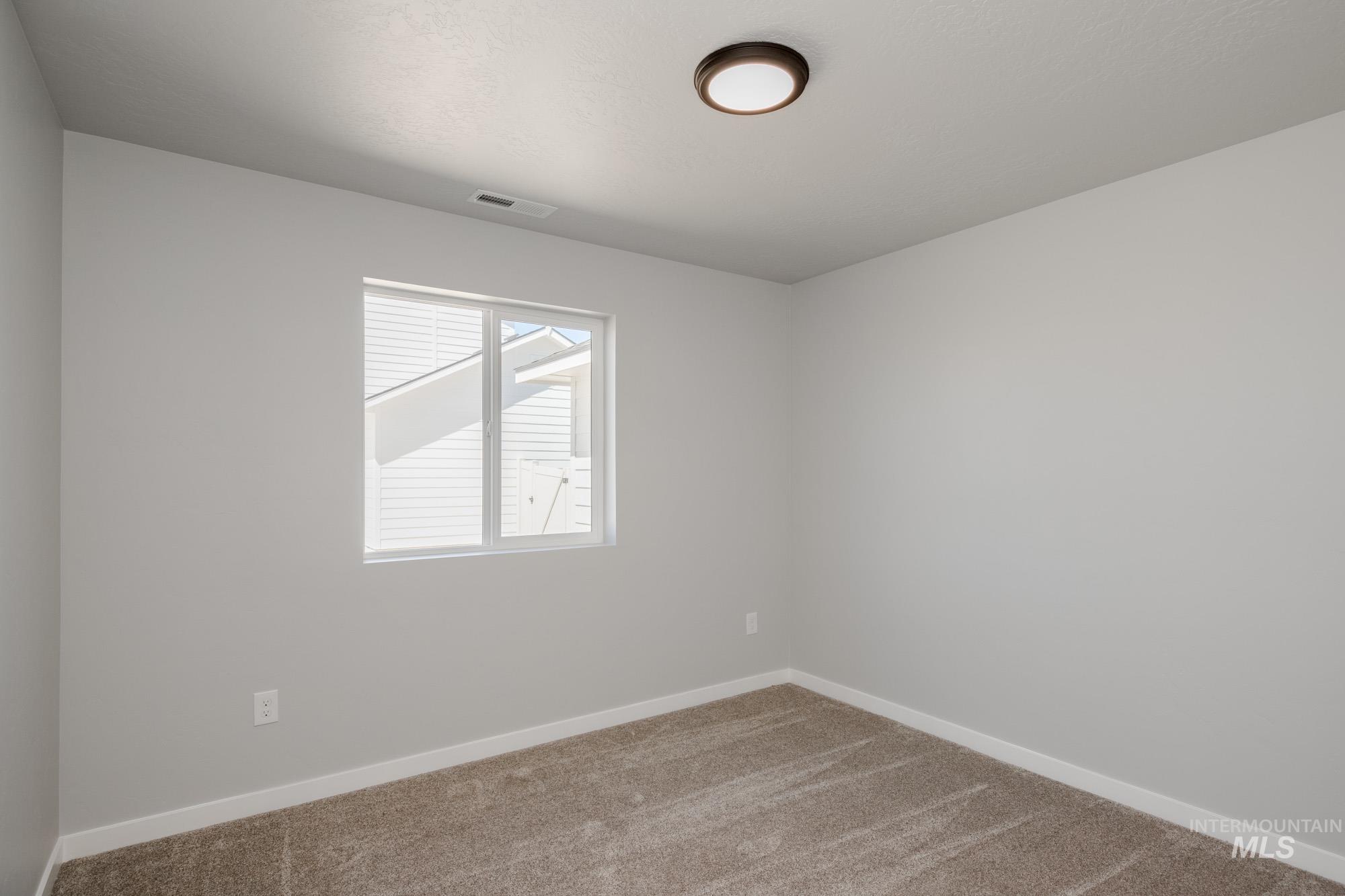 Empty room featuring carpet and baseboards